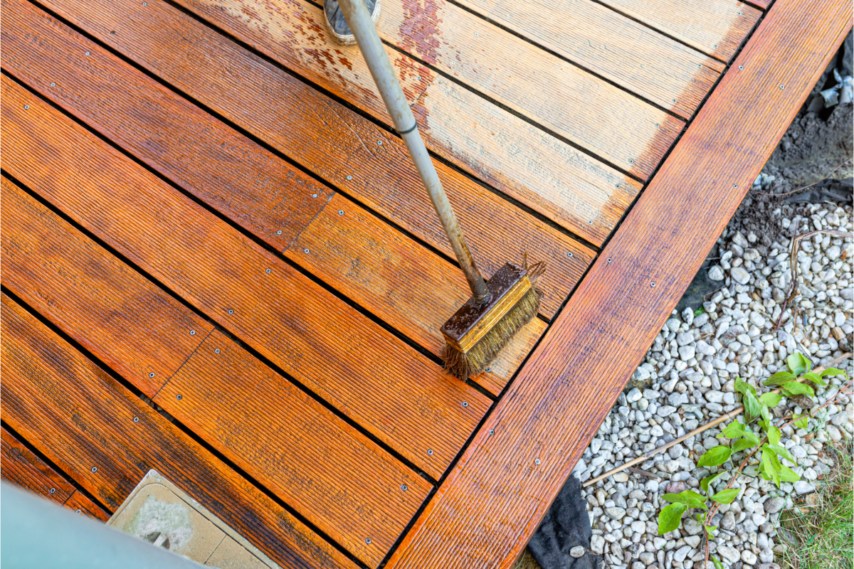 Timber deck being treated with a brush