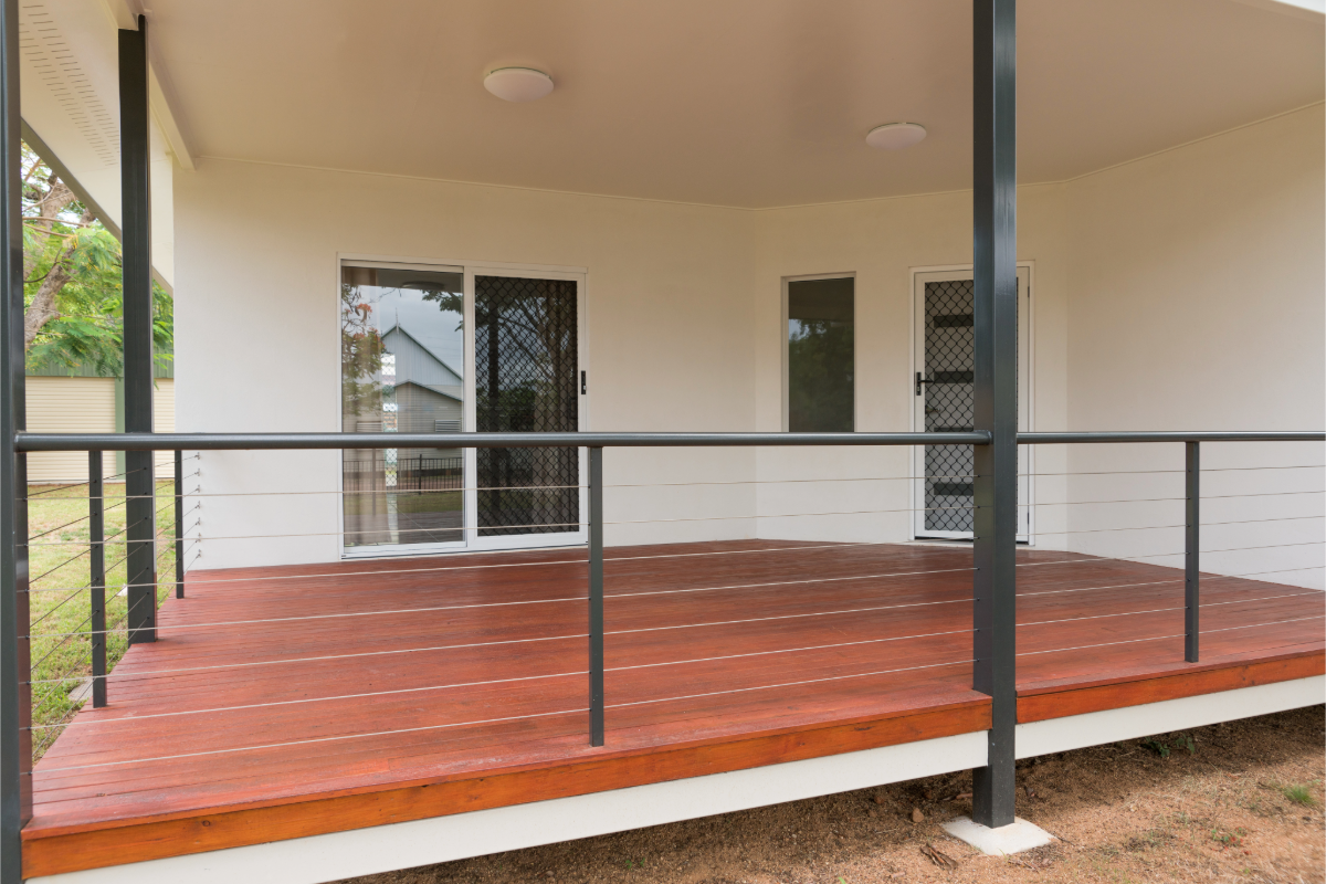 Completed reddish timber deck and verandah with black posts and railing